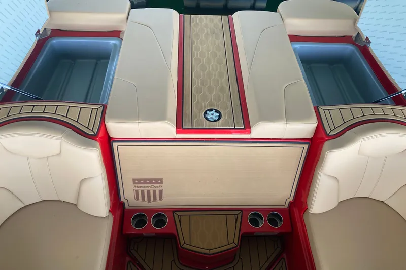 Slide: The Image of 2024 MasterCraft XT22 boat interior with beige seating and red accents. - 11