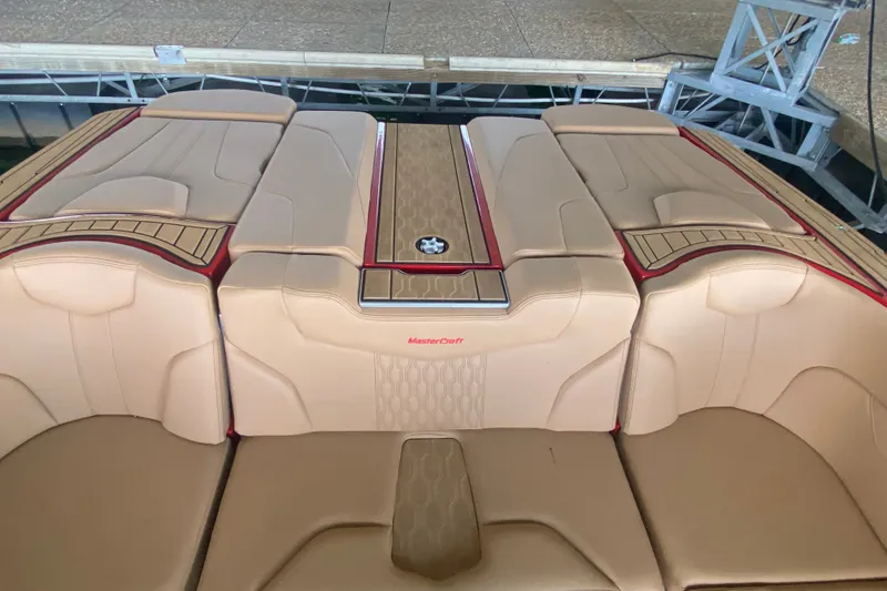 Slide: The Image of 2024 MasterCraft XT22 boat interior with tan upholstery and red accents. - 9