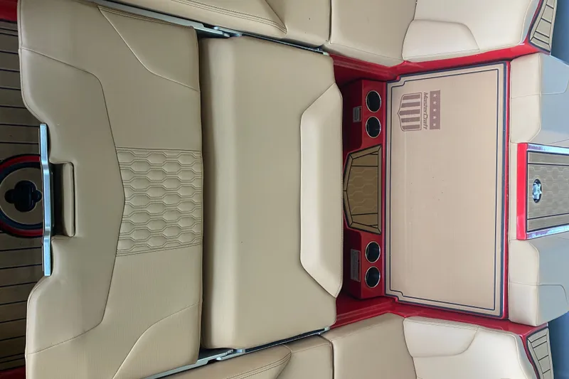 Slide: The Image of 2024 MasterCraft XT22 boat interior with beige seating and red accents. - 10