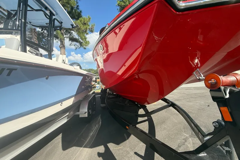 Slide: The Image of 2024 MasterCraft XT22 boat in vibrant red on a trailer, parked beside another boat. - 17