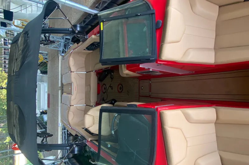 Slide: The Image of 2024 MasterCraft XT22 boat interior with beige seating and red accents. - 5