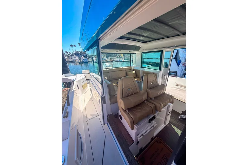 Slide: The Image of 2021 Axopar 37 XC Cross Cabin interior with leather seating, docked at marina. - 23