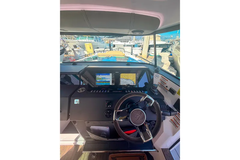 Slide: The Image of Interior view of 2021 Axopar 37 XC Cross Cabin helm with navigation screens and steering wheel. - 19