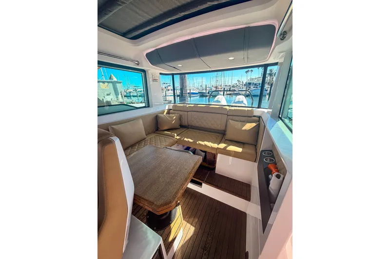 Slide: The Image of Interior of 2021 Axopar 37 XC Cross Cabin with seating and marina view. - 24