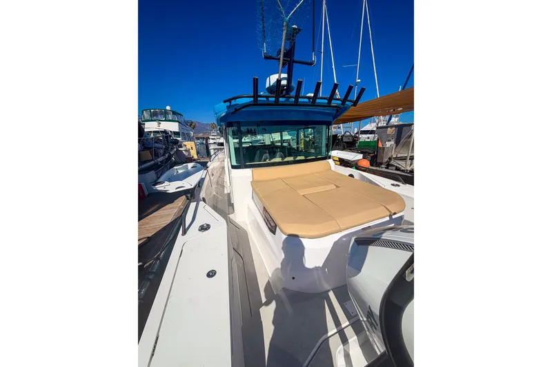 Slide: The Image of 2021 Axopar 37 XC Cross Cabin boat docked, featuring a spacious deck and modern design. - 14