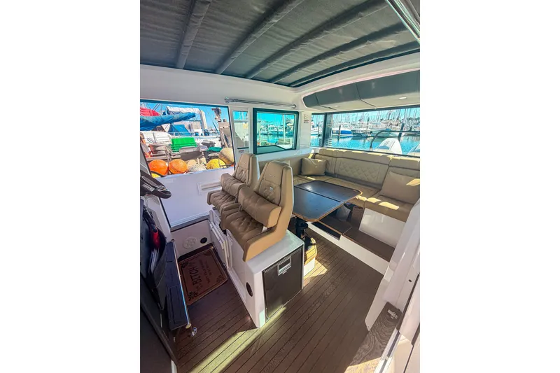 Slide: The Image of Interior of 2021 Axopar 37 XC Cross Cabin with seating and table, docked at marina. - 22