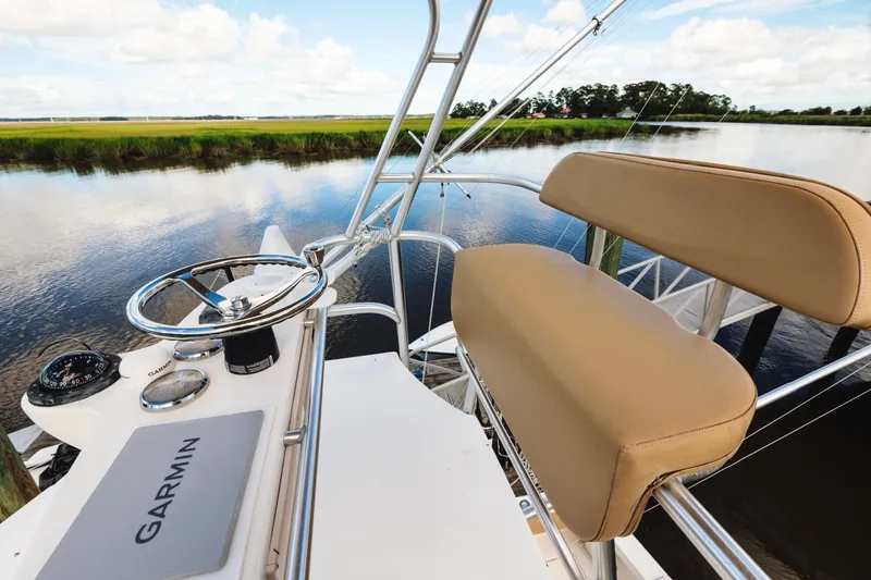 Slide: The Image of 2006 Carolina Classic 32 boat helm with Garmin navigation, overlooking serene water and lush greenery. - 34