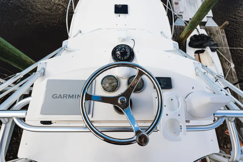 Slide: The Image of Steering wheel and controls of a 2006 Carolina Classic 32 boat. - 33