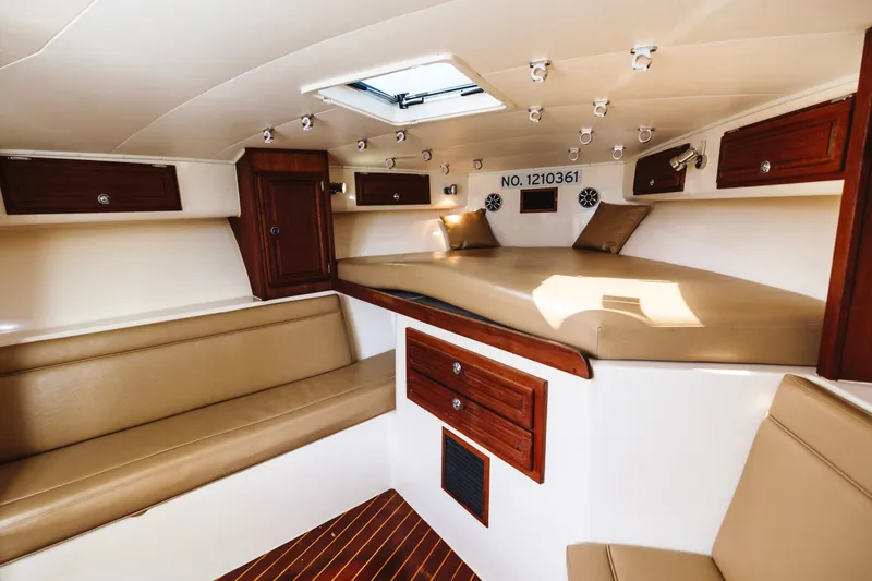 Slide: The Image of Interior of a 2006 Carolina Classic 32 boat with beige seating and wooden cabinets. - 18