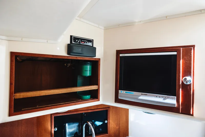 Slide: The Image of Interior of 2006 Carolina Classic 32 boat with TV and wooden cabinet. - 16