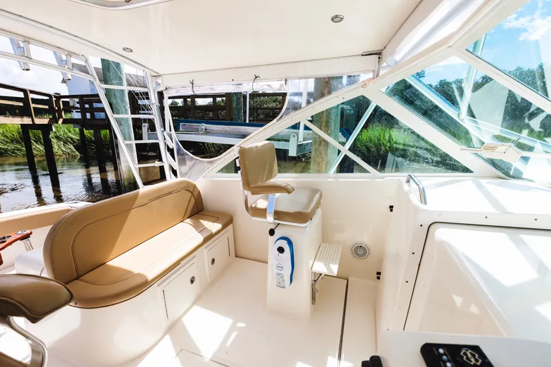 Slide: The Image of Interior of a 2006 Carolina Classic 32 boat with beige seating and helm station. - 21