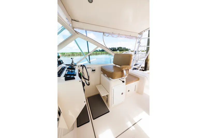 Slide: The Image of Helm of 2006 Carolina Classic 32 boat with beige seating and water view. - 25