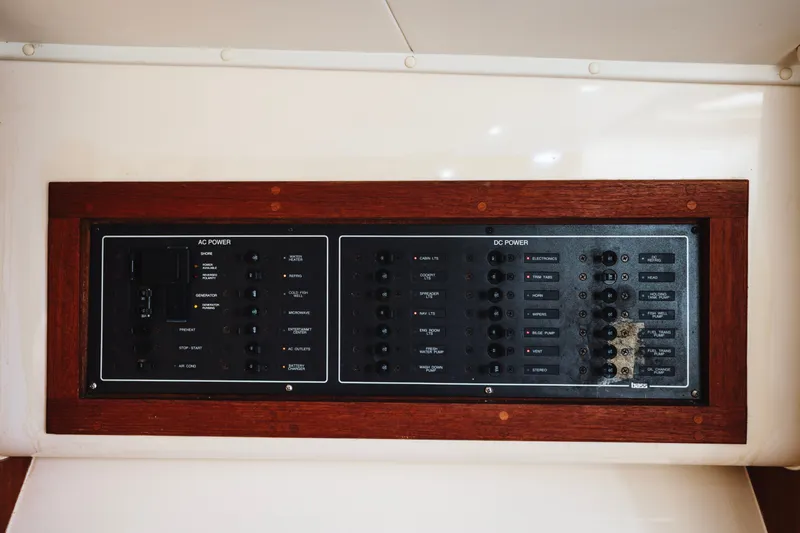 Slide: The Image of Electrical control panel on a 2006 Carolina Classic 32 boat, featuring AC and DC power switches. - 15