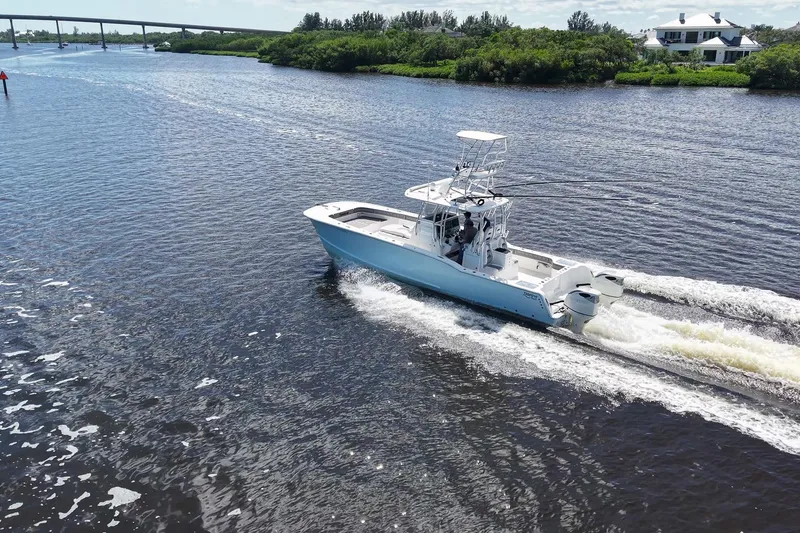 Slide: The Image of 2020 Tideline 365 Offshore boat cruising on a scenic river with lush greenery. - 26