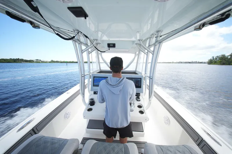 Slide: The Image of Person steering 2020 Tideline 365 Offshore boat on open water. - 81