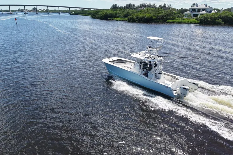 Slide: The Image of 2020 Tideline 365 Offshore boat cruising on a scenic waterway with lush greenery. - 25