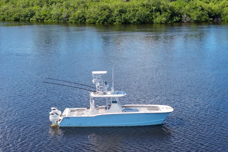 The Image of 2020 Tideline 365 Offshore boat on calm water with lush green shoreline. - 2