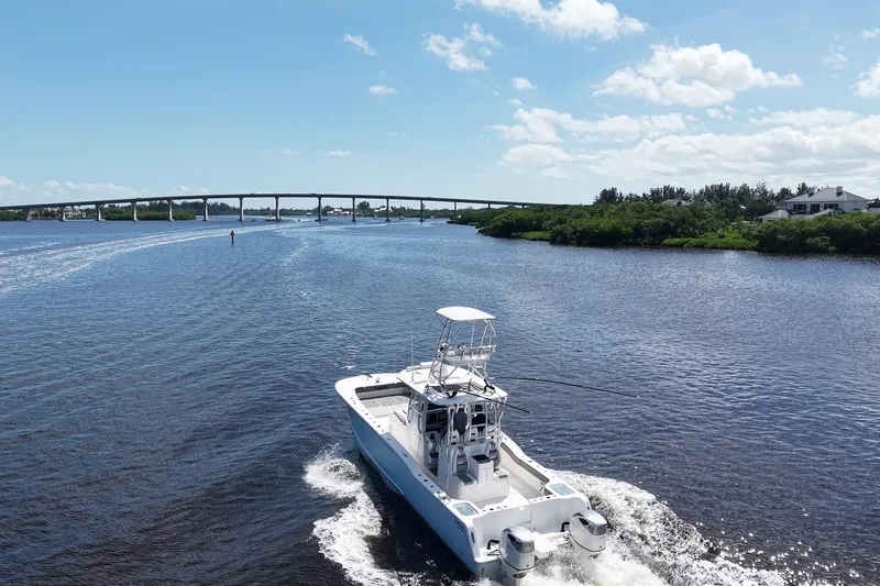 Slide: The Image of 2020 Tideline 365 Offshore boat cruising on a scenic river under a clear blue sky. - 24