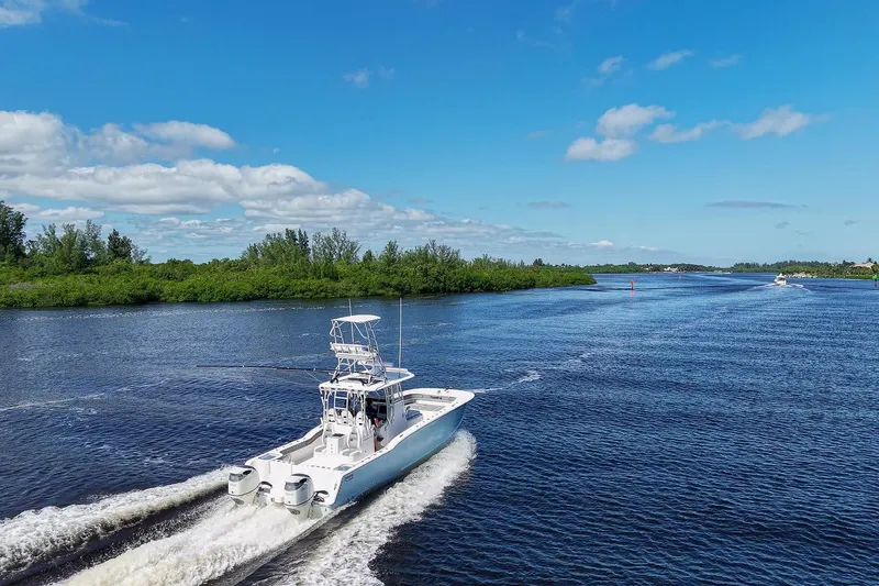 Slide: The Image of 2020 Tideline 365 Offshore boat cruising on a scenic river under a clear blue sky. - 15