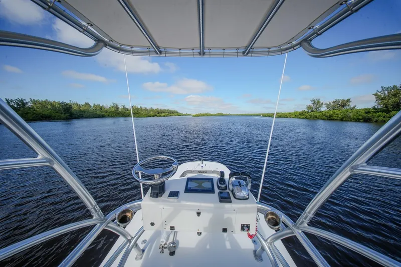 Slide: The Image of View from Tideline 365 Offshore boat, 2020 model, navigating a serene river under a clear sky. - 72