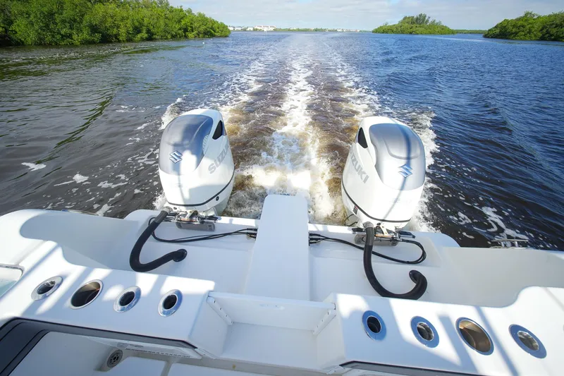 Slide: The Image of 2020 Tideline 365 Offshore boat with dual Suzuki outboard motors cruising on a river. - 40