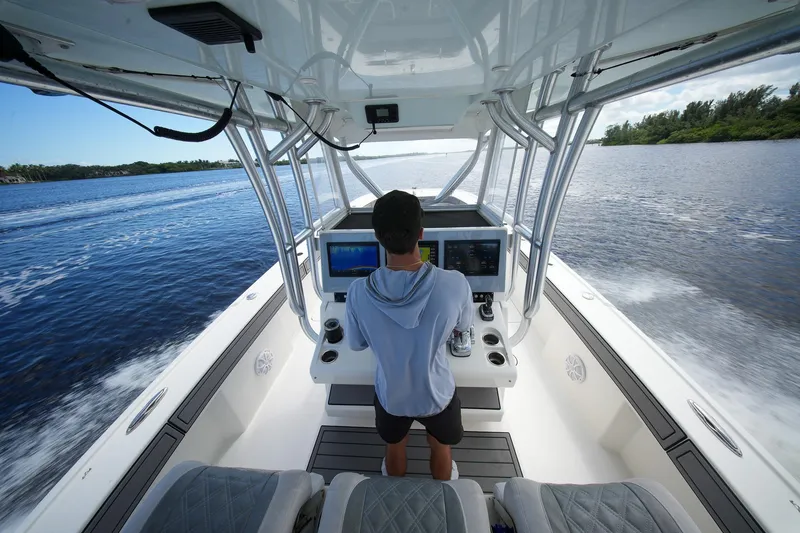 Slide: The Image of Person steering a 2020 Tideline 365 Offshore boat on a scenic waterway. - 79