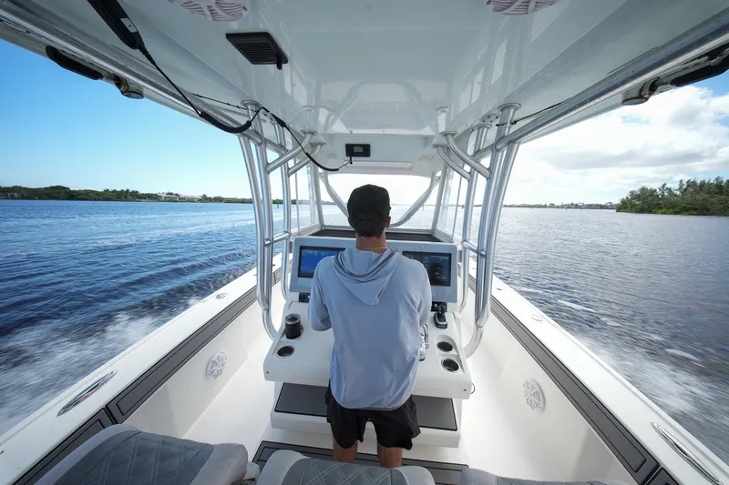 Slide: The Image of Person steering 2020 Tideline 365 Offshore boat on open water. - 80
