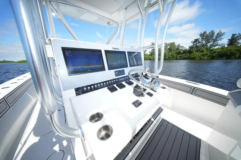 Slide: The Image of 2020 Tideline 365 Offshore boat dashboard with dual screens and steering wheel on a sunny day. - 50
