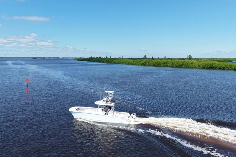 Slide: The Image of 2020 Tideline 365 Offshore boat cruising on a serene river under a clear blue sky. - 21