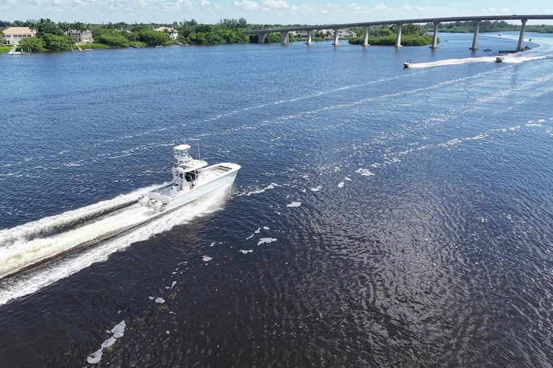 Slide: The Image of 2020 Tideline 365 Offshore boat cruising on a scenic river near a bridge. - 28