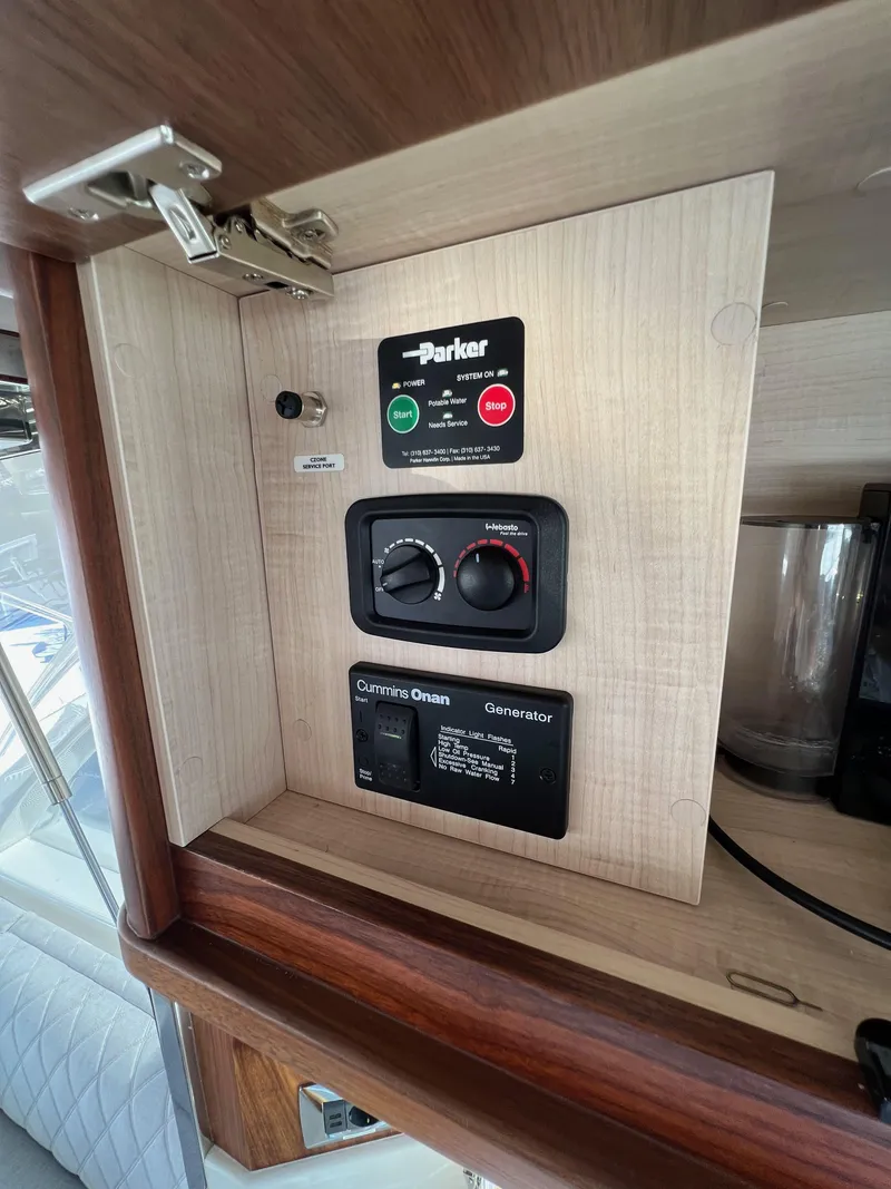 Slide: The Image of Control panel inside 2022 Riviera 505 SUV yacht, featuring Parker and Cummins Onan generator controls. - 20