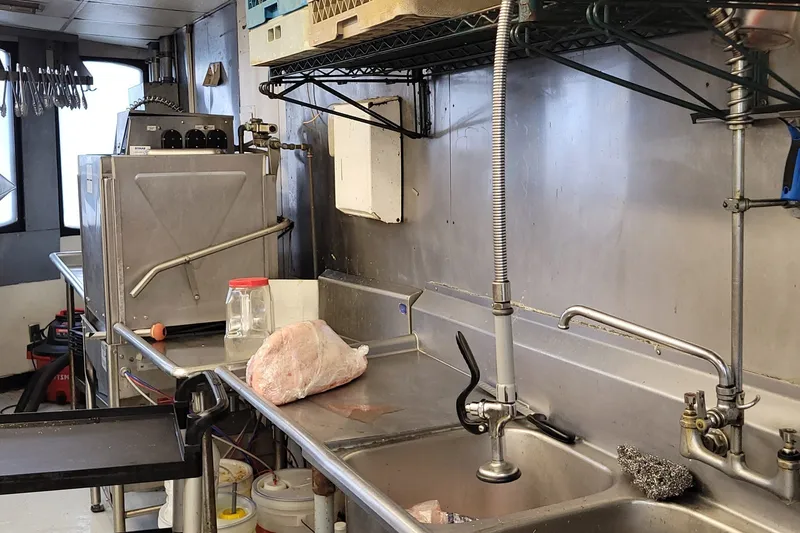 Slide: The Image of Industrial kitchen sink area with stainless steel surfaces and cleaning supplies, 1985 Custom model. - 6