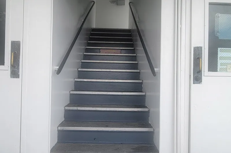 Slide: The Image of Staircase inside 1985 Custom Dinner Excursion Passenger vehicle, featuring metal railings and doors. - 11