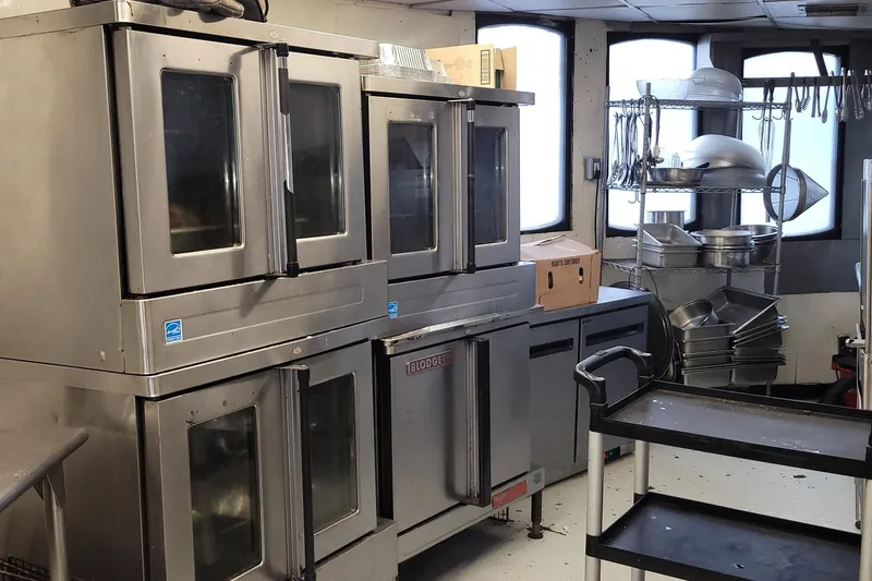 Slide: The Image of Commercial kitchen with stainless steel ovens, shelves, and cookware on a 1985 custom passenger vessel. - 7