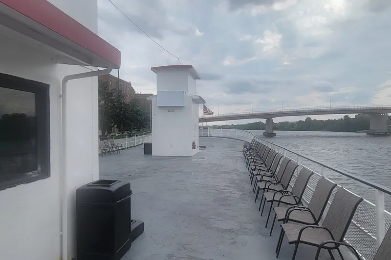 Slide: The Image of Deck of 1985 custom passenger excursion boat with chairs, river view, and bridge in background. - 13
