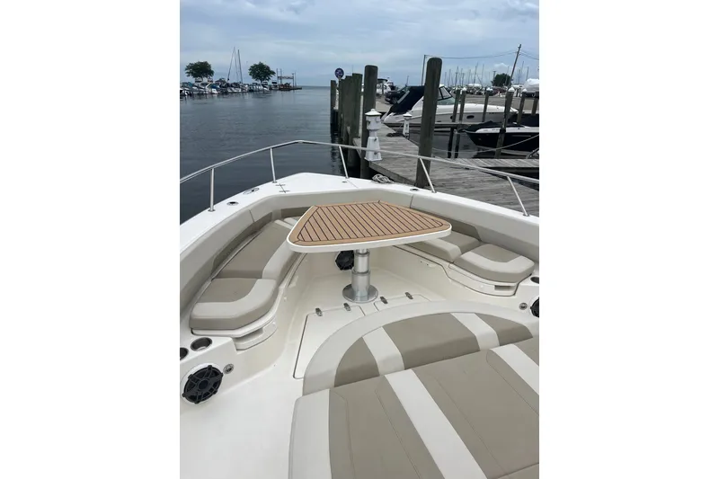 Slide: The Image of 2023 Boston Whaler 420 Outrage boat interior with seating and table at dock. - 15