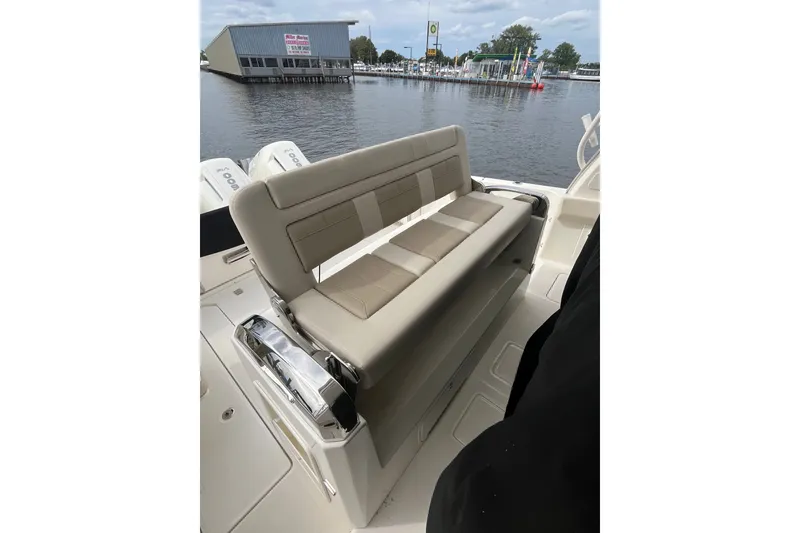 Slide: The Image of 2023 Boston Whaler 420 Outrage boat interior with beige seating, dockside view. - 17