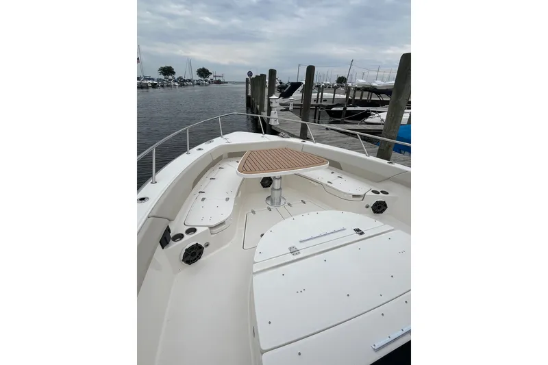 Slide: The Image of 2023 Boston Whaler 420 Outrage boat docked, featuring spacious deck and seating area. - 28