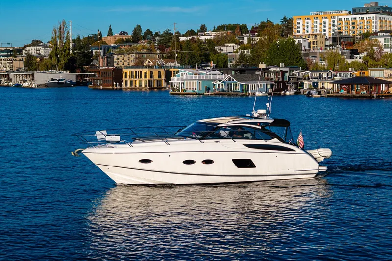 The Image of 2016 Princess V39 yacht cruising on a scenic waterfront with cityscape background. - 0