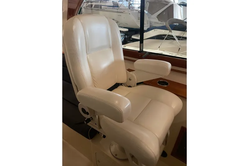 Slide: The Image of Captain's chair on 2014 Hinckley Talaria 34 yacht, featuring luxurious white leather upholstery. - 9