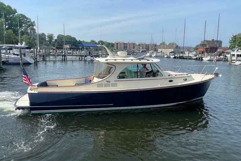 Slide: The Image of 2014 Hinckley Talaria 34 yacht cruising in a marina with American flag. - 1