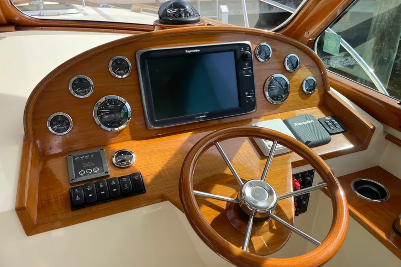 Slide: The Image of Helm of 2014 Hinckley Talaria 34 with wooden dashboard and navigation instruments. - 11