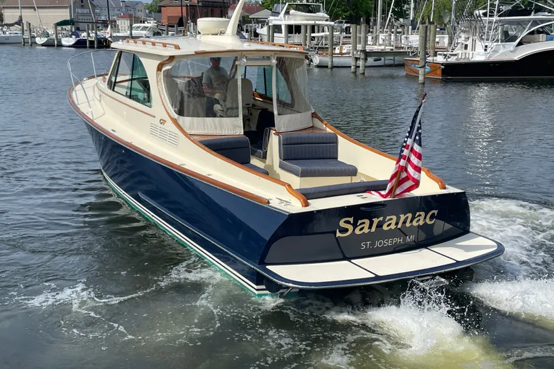 Slide: The Image of 2014 Hinckley Talaria 34 boat named "Saranac" cruising in a marina. - 3