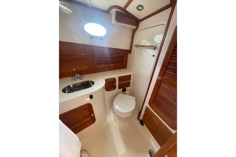 Slide: The Image of 2014 Hinckley Talaria 34 yacht bathroom with wooden cabinetry and modern fixtures. - 18