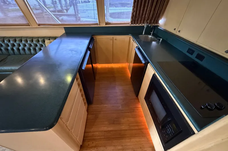 Slide: The Image of Luxurious kitchen interior of a 1991 Bertram 60 Convertible yacht with modern appliances. - 25