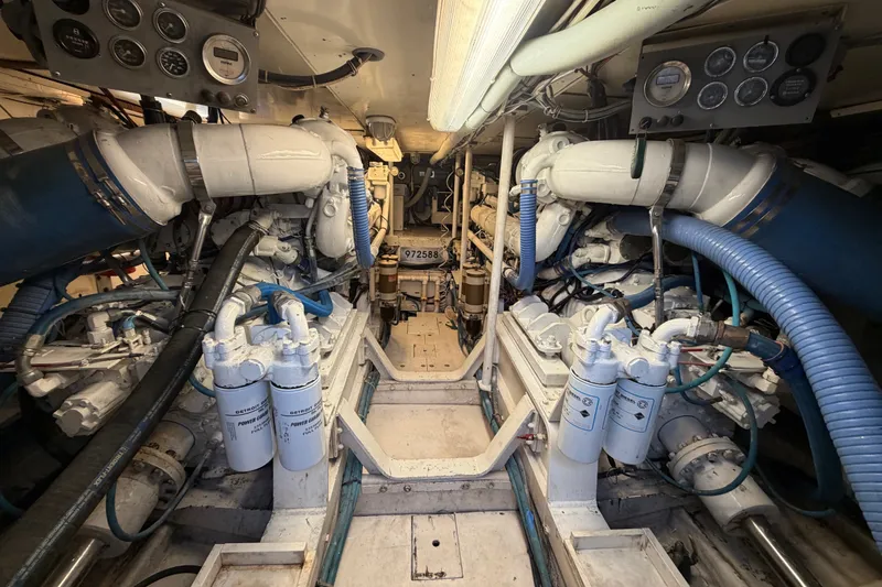 Slide: The Image of Engine room of a 1991 Bertram 60 Convertible yacht, showcasing complex machinery and gauges. - 21