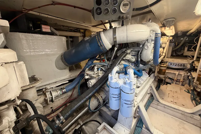 Slide: The Image of Engine room of a 1991 Bertram 60 Convertible yacht, showcasing complex machinery and components. - 22