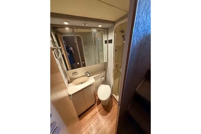 Slide: The Image of Bathroom interior of 1991 Bertram 60 Convertible yacht, featuring sink, toilet, and shower. - 15