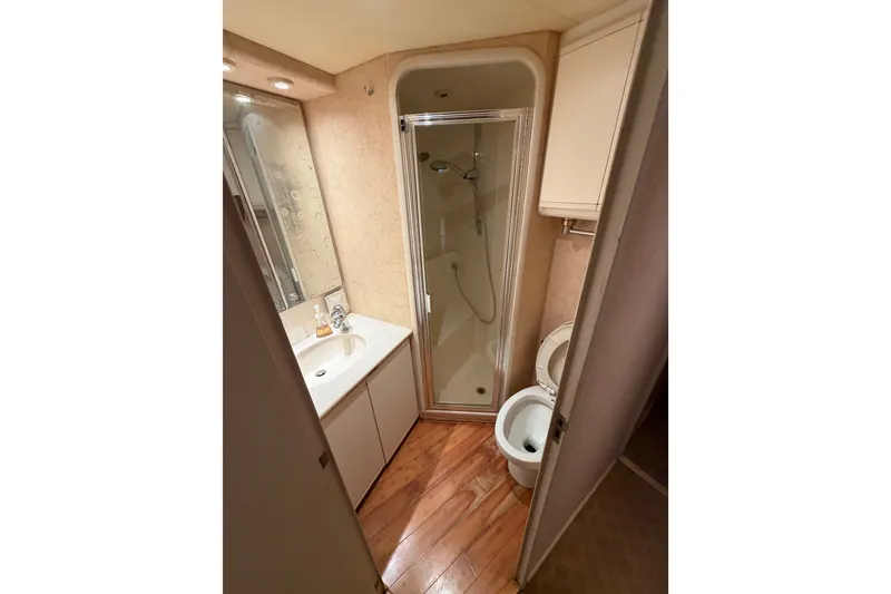 Slide: The Image of Bathroom interior of 1991 Bertram 60 Convertible yacht with shower, sink, and toilet. - 18