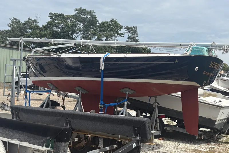 Slide: The Image of 2019 Alerion Express 20 sailboat on stands, blue hull, red keel, outdoor setting. - 8